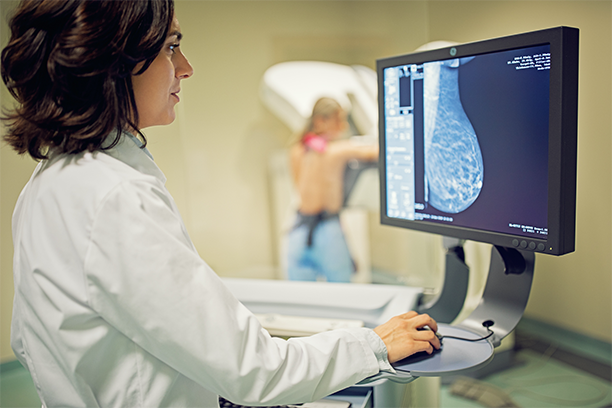 Doctor is working with mammography X-ray scanner